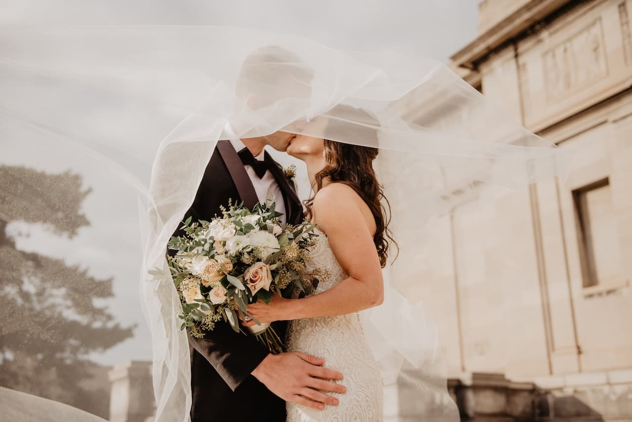 A couple kissing after just getting married.
