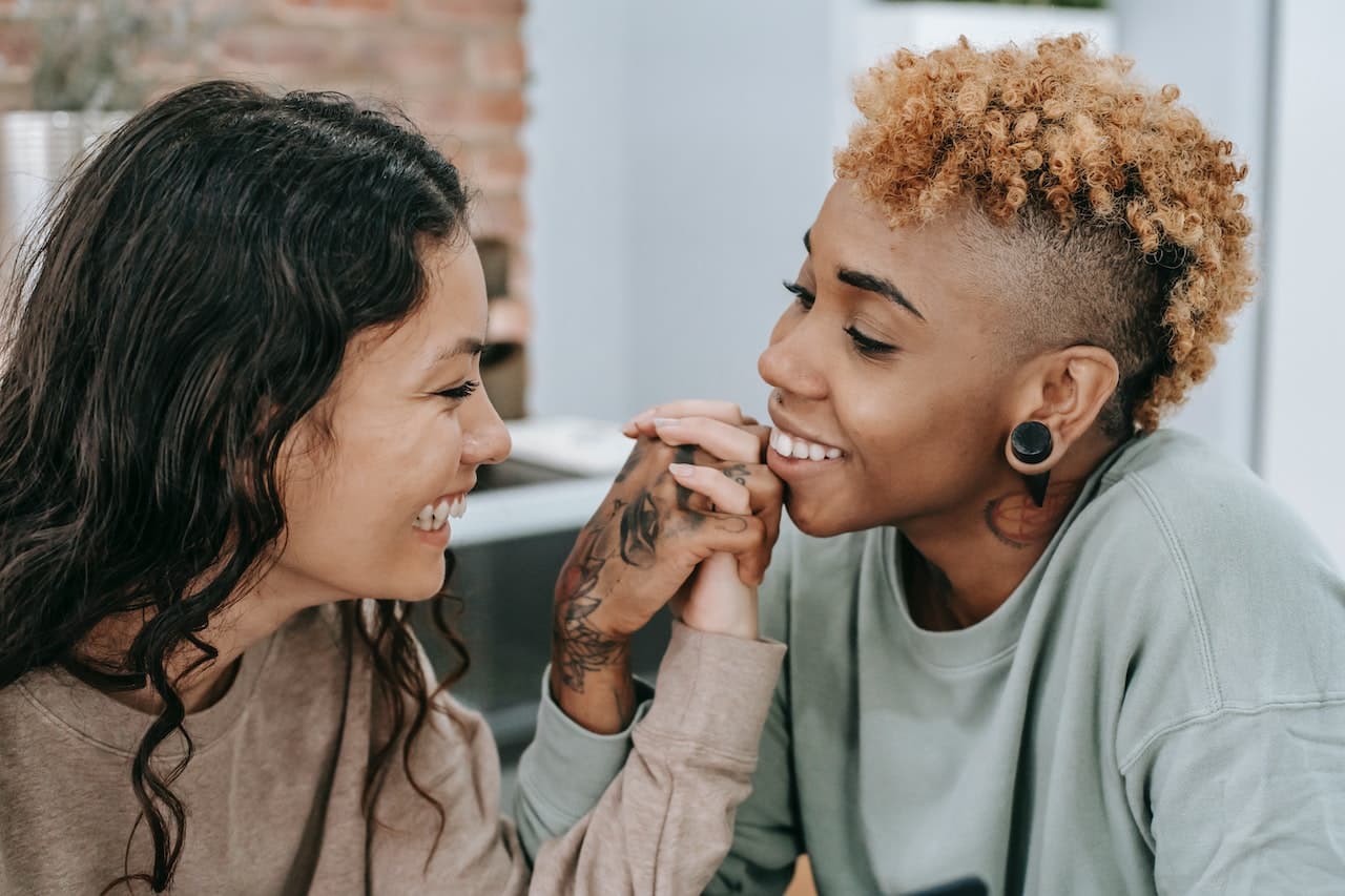 A queer couple demonstrating physical intimacy in relationships through touch.