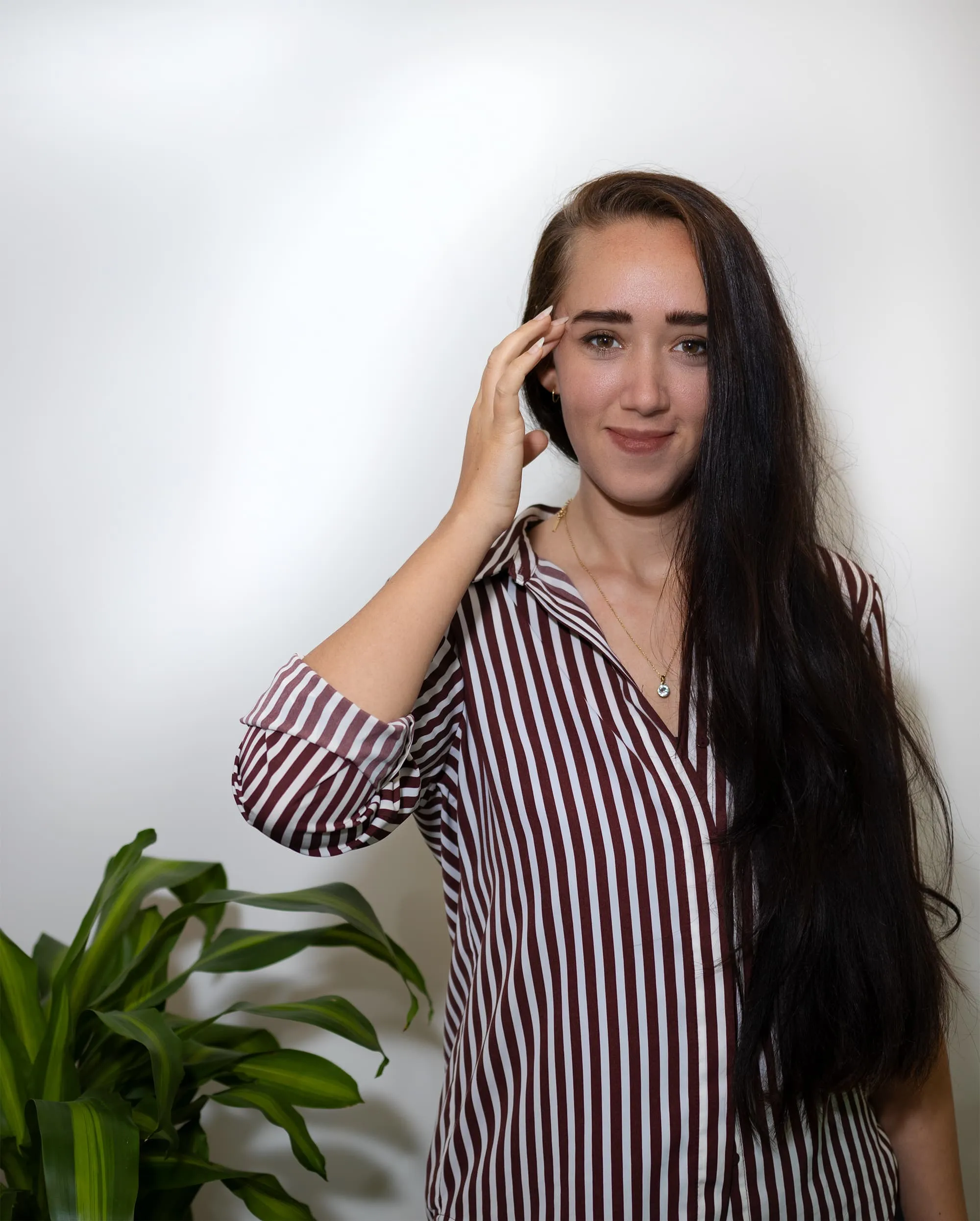 Photo of Zoe West demonstrating EFT tapping by gently tapping on the side of eye point.